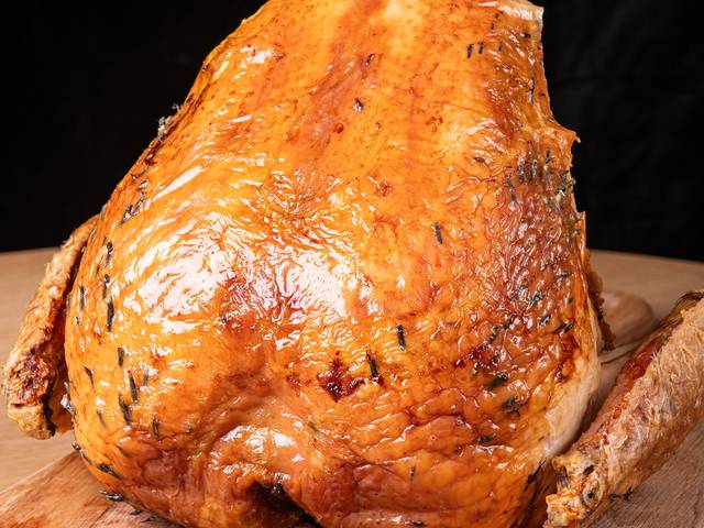 A roasted Shropshire Bronze crown, golden brown, on a wooden board