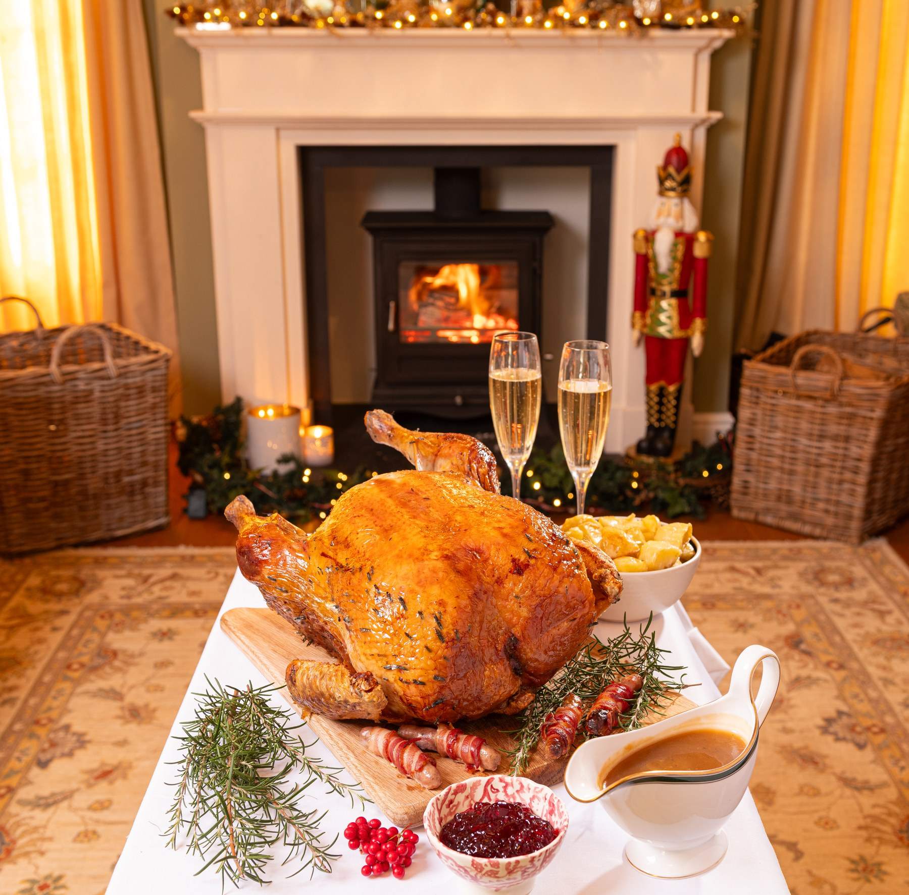 A roast Shropshire Bronze turkey on a festive table in front of a lit wood burner