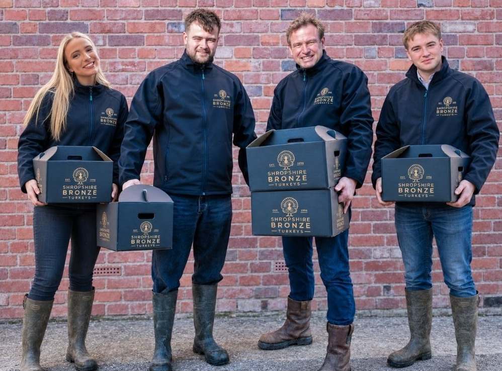 David Cartwright and his three children in Shropshire Bronze jackets, each holding a boxed turkey