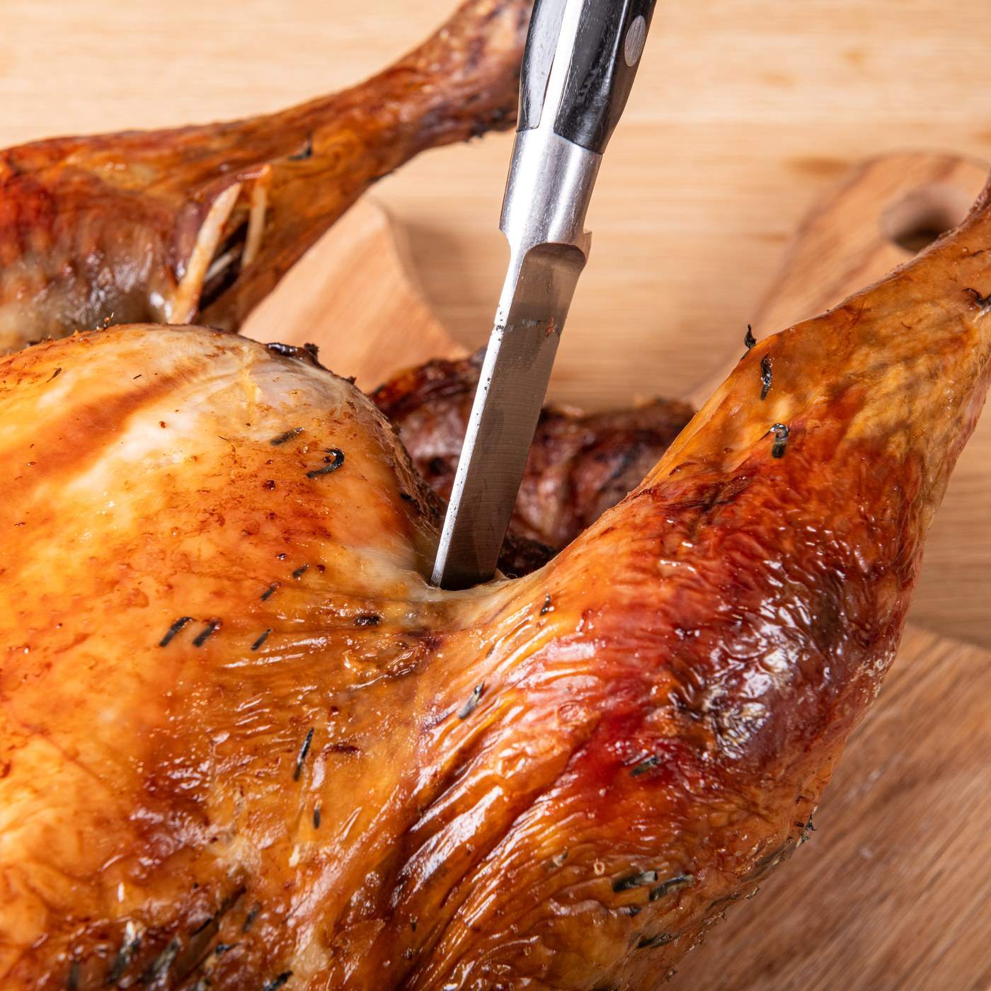 A meat thermometer in the thickest part of the thigh of a roast turkey